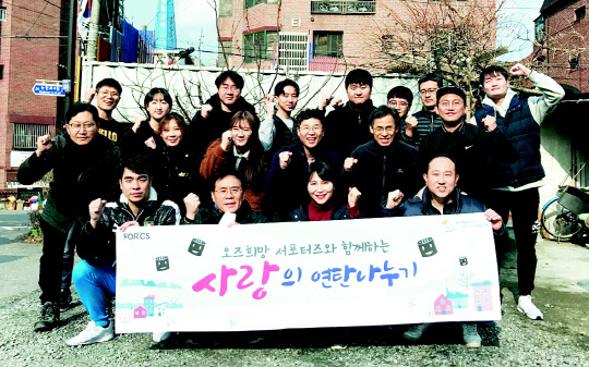 포시에스 임직원과 'OZ 희망 서포터즈' 회원들이 연탄 배달 봉사활동을 한 후 사진을 찍고 있다.  포시에스 제공